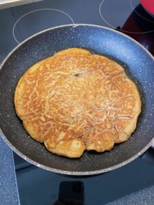 Scrambled proteïne pancakes omgedraaid in de pan